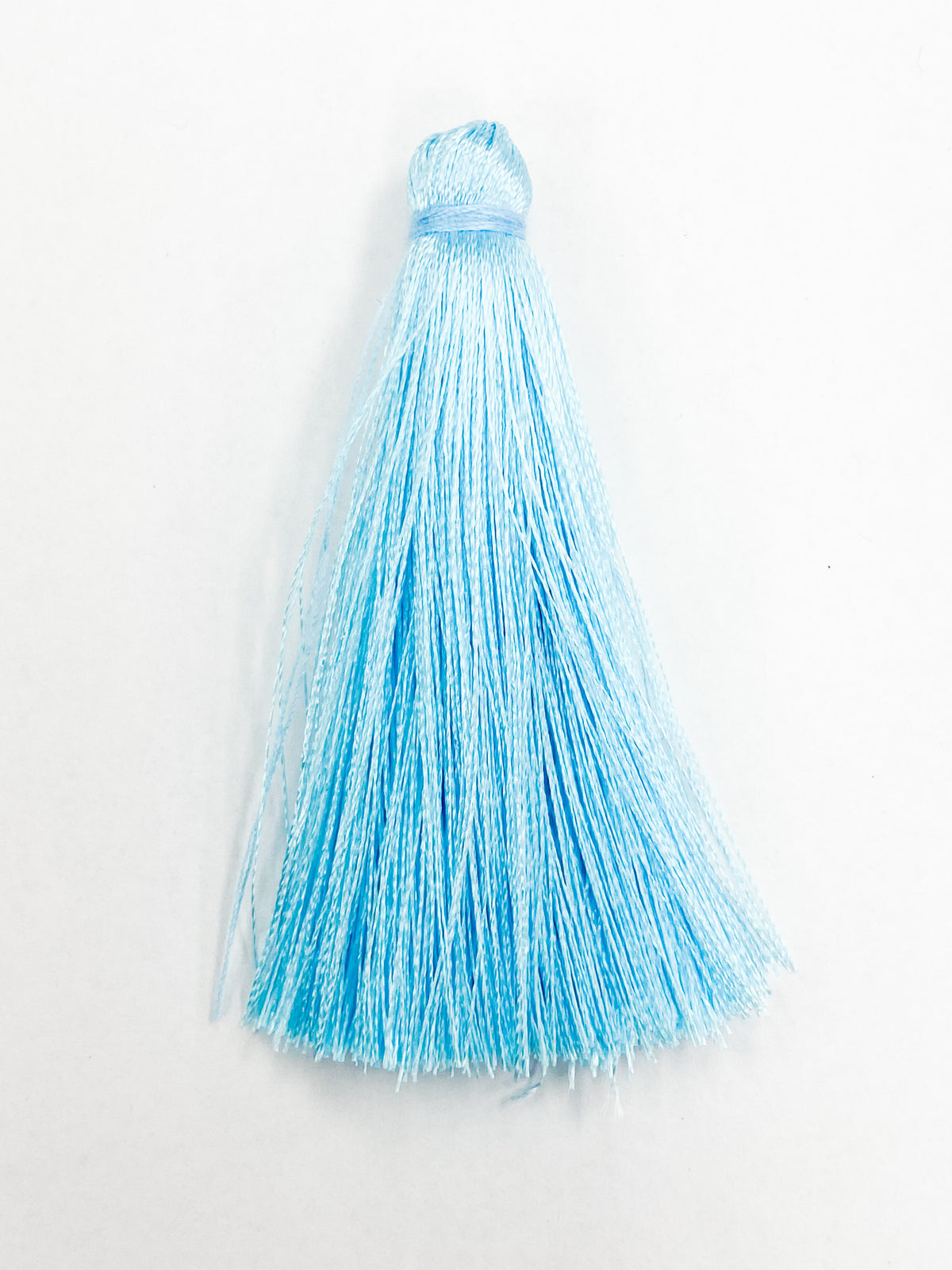Light Blue Coloured Tassel, 65mmL x 10mm. Polyester fibre.